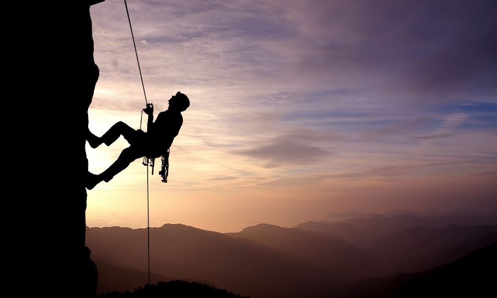 a man flying through the air on a cloudy day